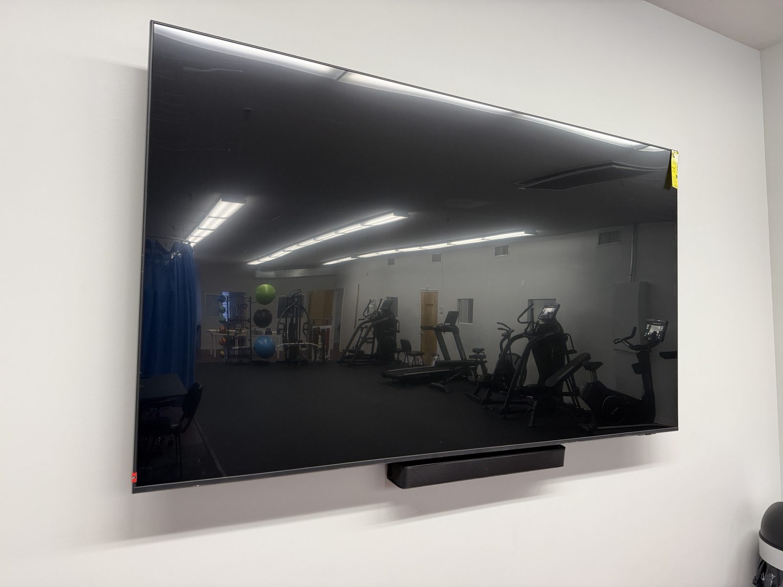 Display and soundbar in the gym, cabling concealed in the wall.